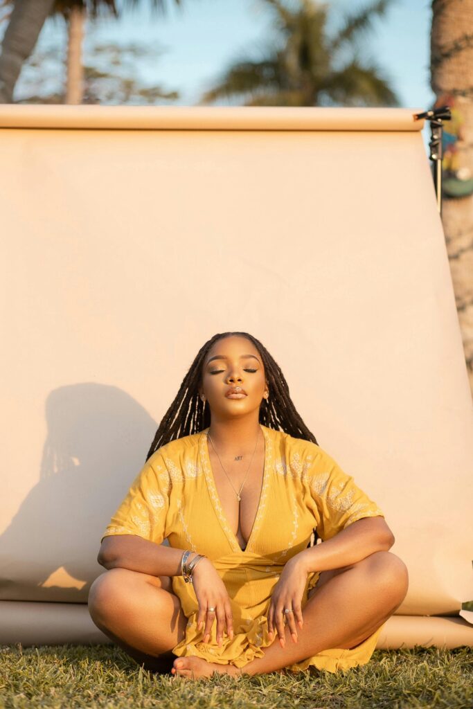 Tranquil outdoor meditation scene with a woman in a yellow dress enjoying nature in The Bahamas.